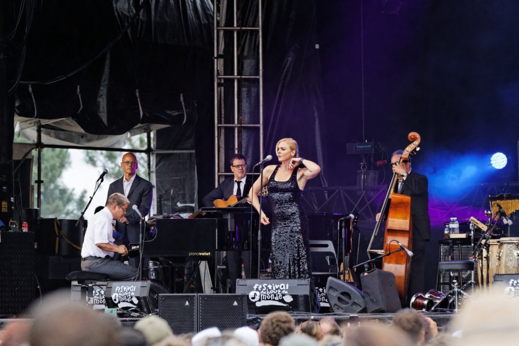 Pink Martini auf einer Festivalbühne, das Ensemble mit Bläsern, Streichern und Sängerin